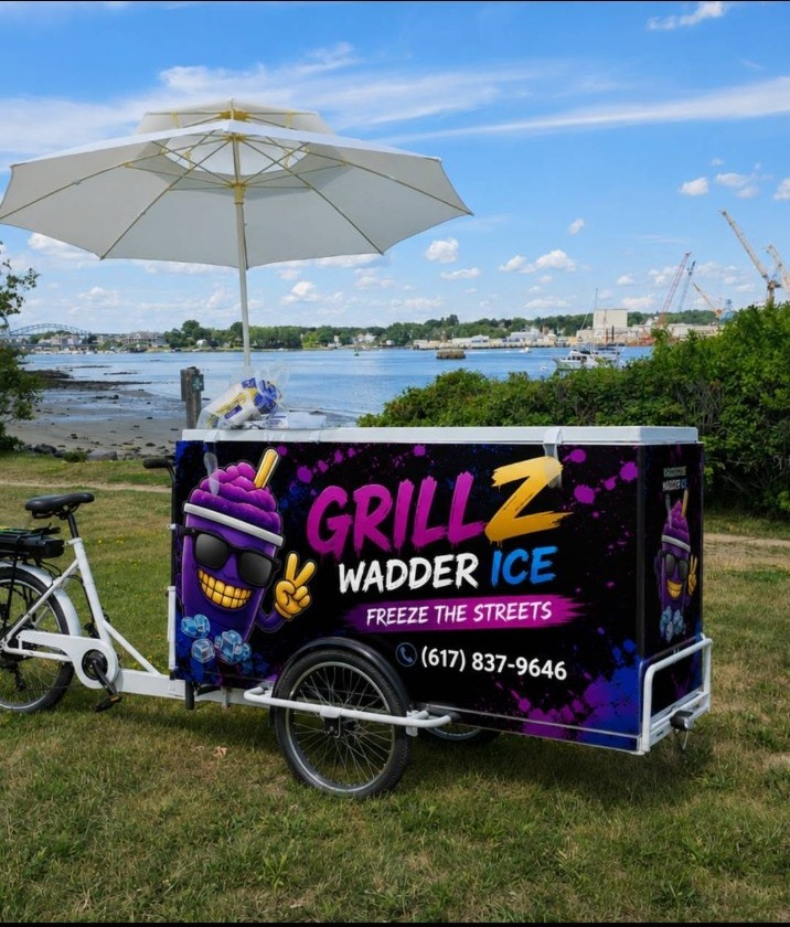 The Grillz Wadder Ice tricycle and wrapped cooler set up beside the waterfront